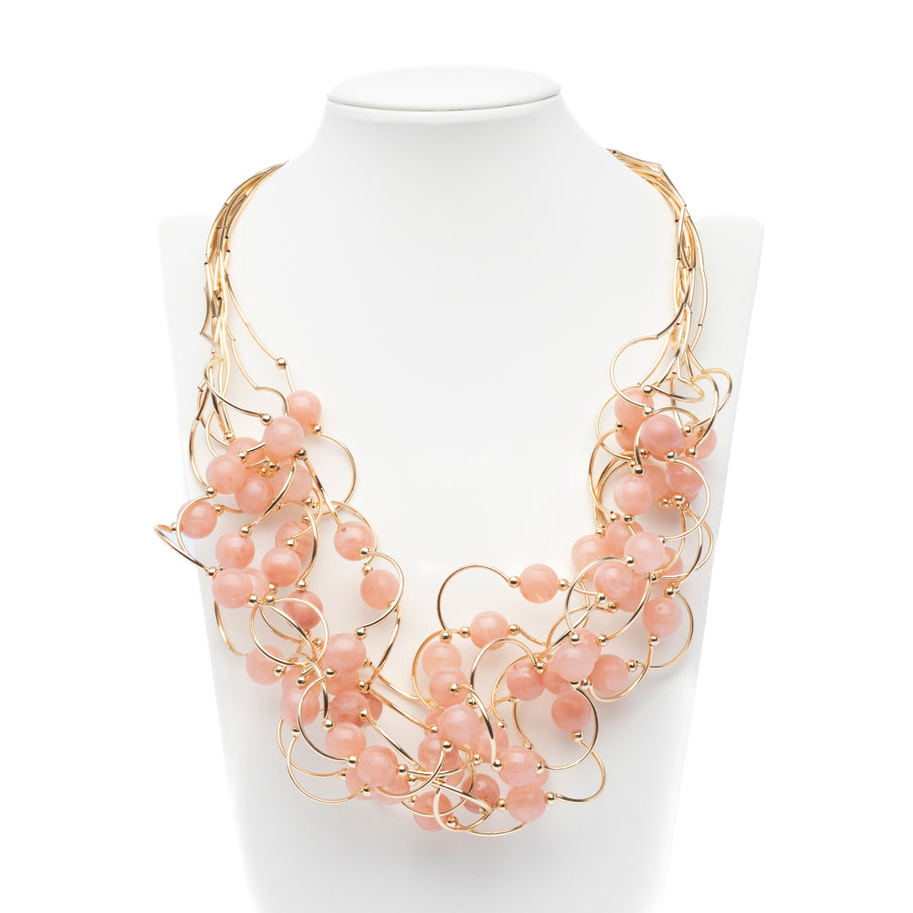 Collana multifili dorata con pietre rosa.