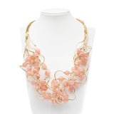 Collana multifili dorata con pietre rosa.