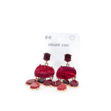 Orecchino pendente con pietre rosse.